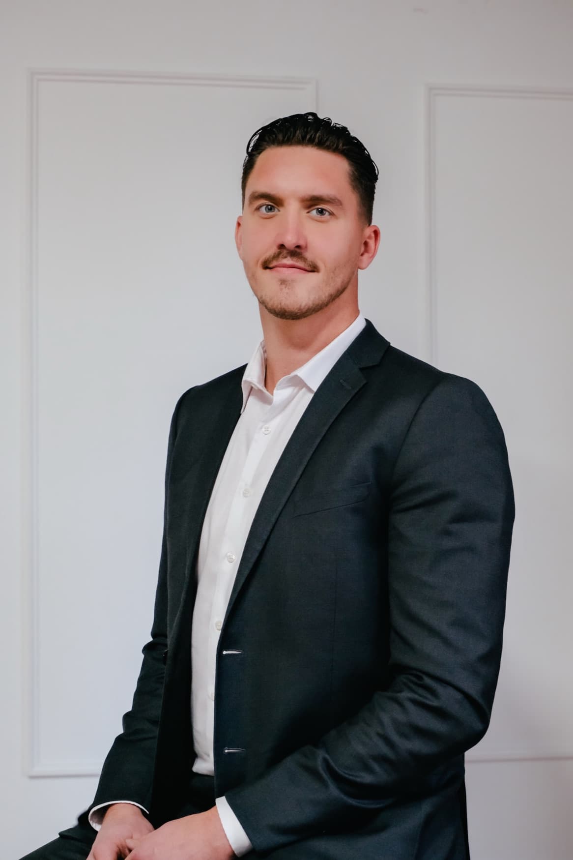 Professional portrait of Ryan Stulp standing in a dark suit